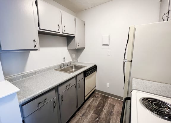 a kitchen with white cabinets and white appliances  at Summit East - A Senior Community, Cincinnati, Ohio