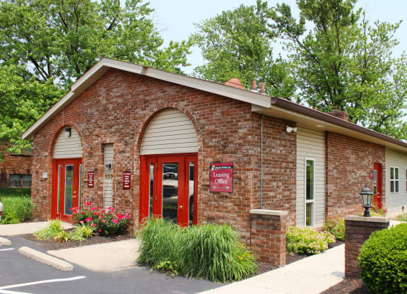 a brick building with a red door and a sign on it  at Four Worlds Apartments, Cincinnati, OH
