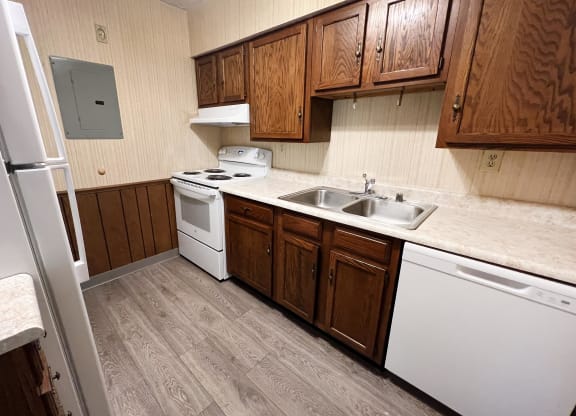 a kitchen with white appliances and wooden cabinets  at Devou Village, Ft. Wright