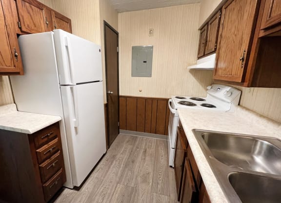 a kitchen with a white refrigerator freezer next to a stove top oven  at Devou Village, Ft. Wright