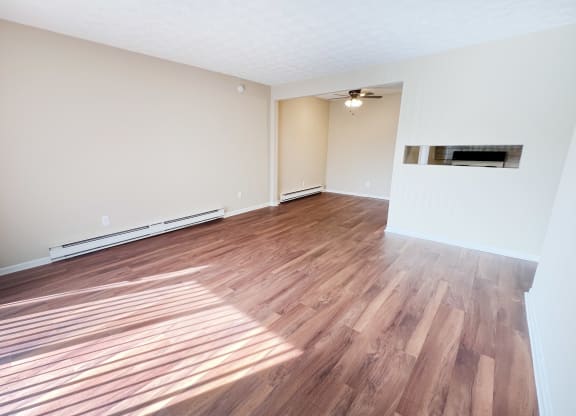 the living room and dining room of an empty house with wood flooring at Concord Woods Apartments, Milford, OH 45150
