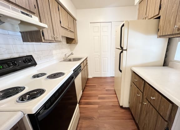 a kitchen with white appliances and wooden cabinets at Concord Woods Apartments, Milford, Ohio 45150