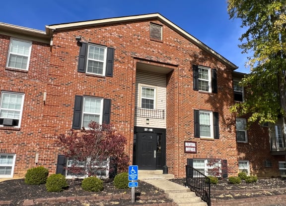 a red brick apartment building with a black door and stairs at Concord Woods Apartments, Milford, Ohio