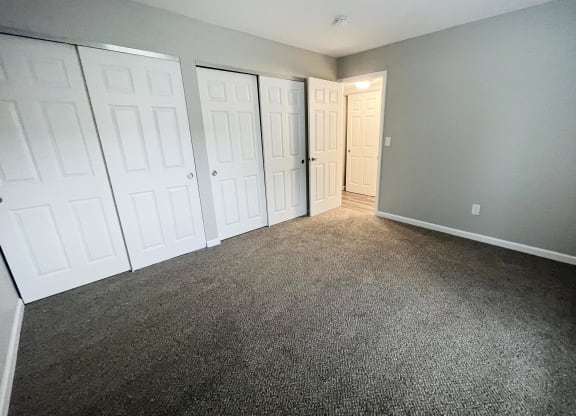 a bedroom with two closets and a door to a bathroom  at Timber Ridge Apartments, Cincinnati, Ohio