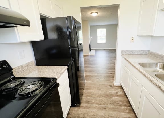 a kitchen with white cabinets and black appliances  at The Villas at Kingswood, West Chester, 45069