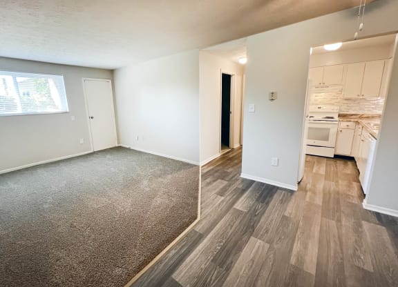 an empty living room and kitchen with wood flooring and a window at Oakwood Apartments, Florence, KY