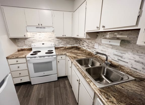 Kitchen with appliances and white cabinets at Oakwood Apartments, Florence