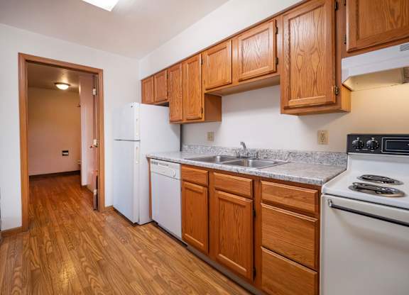 A kitchen with wooden cabinets and a white refrigerator.