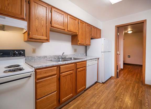 A kitchen with wooden cabinets and a white refrigerator.