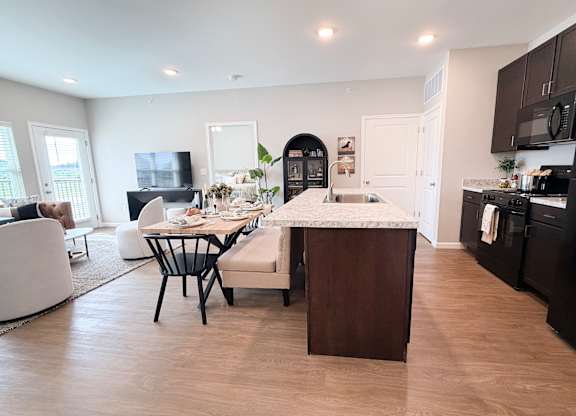 A modern kitchen with dark brown cabinets and a white island.