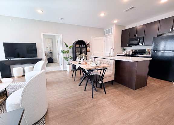 A modern kitchen with a dining table and chairs.