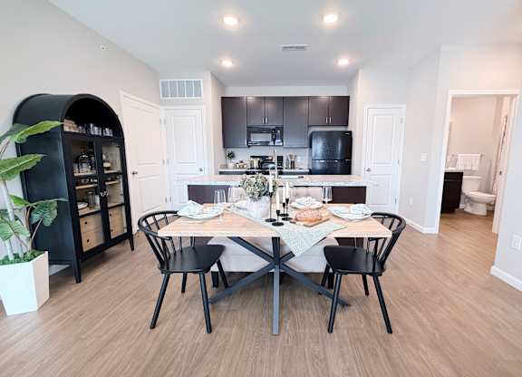 A modern kitchen with a dining table set for two.