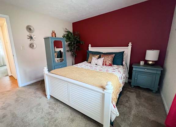 A bedroom with a white bed and a blue cabinet.