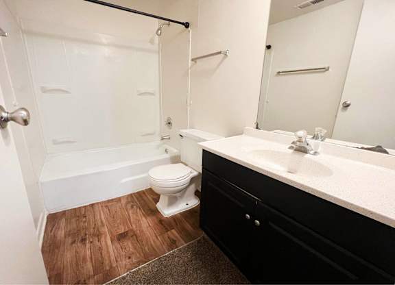 A white bathroom with a toilet, sink, and bathtub.
