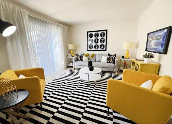 A living room with yellow chairs and a black and white checkered floor.