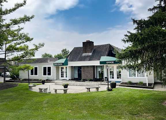 A white building with a green sign that says