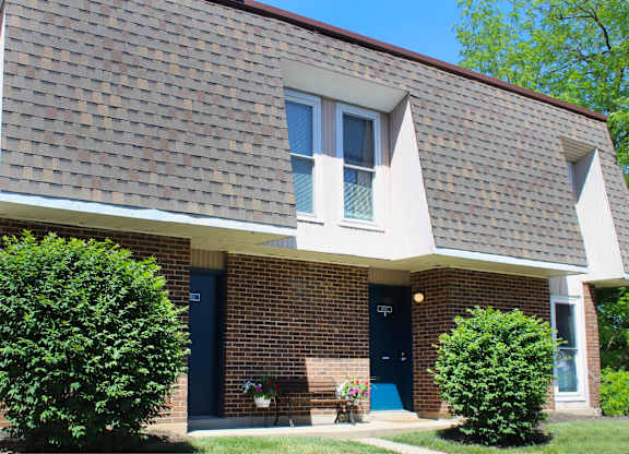 A house with a blue door and a brick wall.