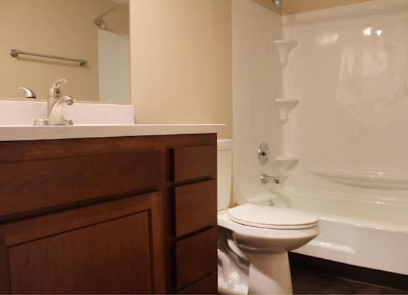 A white toilet sits next to a bathtub in a bathroom.
