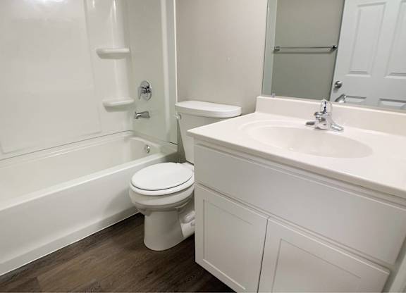 A white bathroom with a toilet, sink, and bathtub.