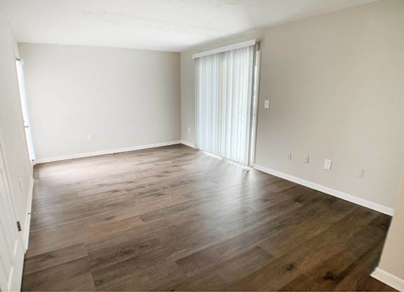 A room with wooden flooring and a white door.