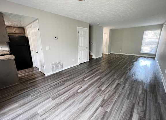 A room with wooden flooring and white walls.