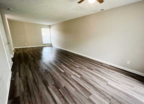 A room with wooden flooring and a ceiling fan.