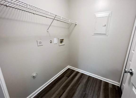 A white wall with a light switch and a white door.