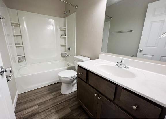 A white bathroom with a toilet, sink, and bathtub.