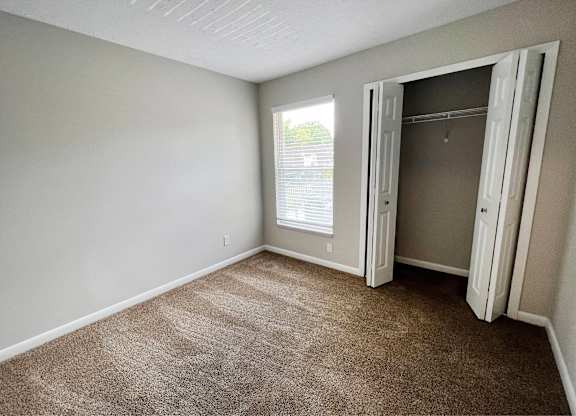 A room with a carpeted floor and a doorway leading to another room.