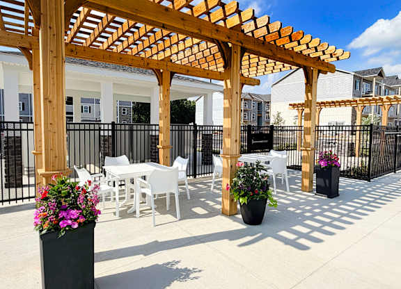 Outdoor patio with white furniture and pergola shade at The Meridian on 32 Apartments, Ohio, 45103