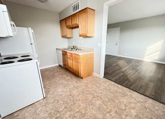 an empty kitchen with a stove refrigerator and sink