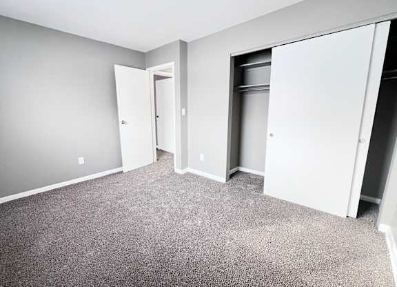 A room with grey carpet and white walls.