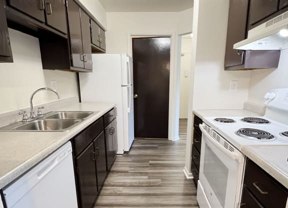 an empty kitchen with white appliances and black and white cabinets at Four Worlds Apartments, Ohio, 45231