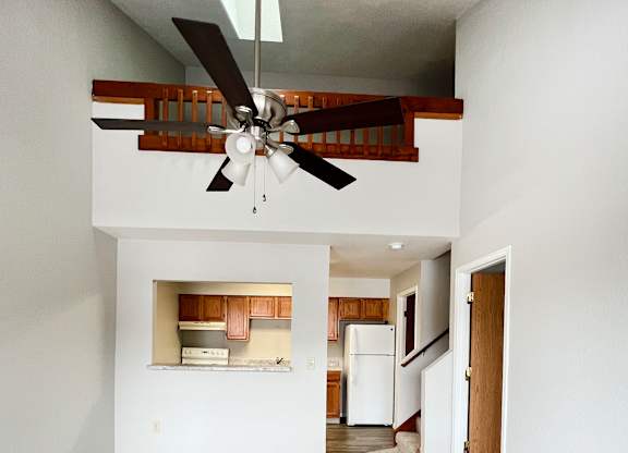 A room with a ceiling fan and carpeted floor.
