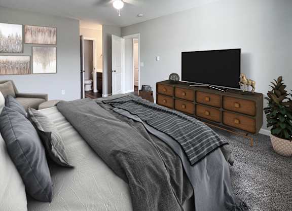 A bedroom with a large bed and a television on a dresser.