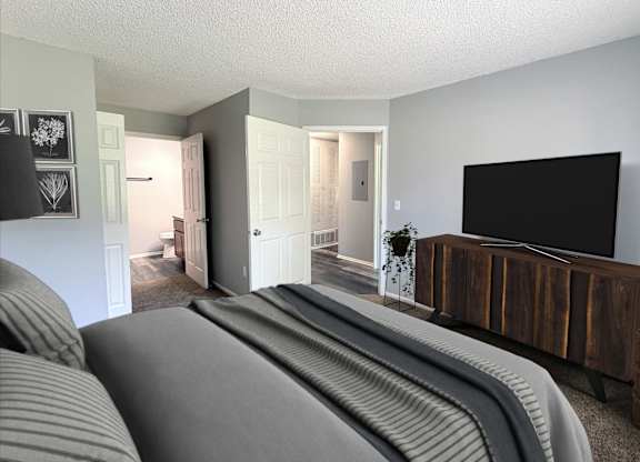 A living room with a grey sofa and a wooden tv stand.