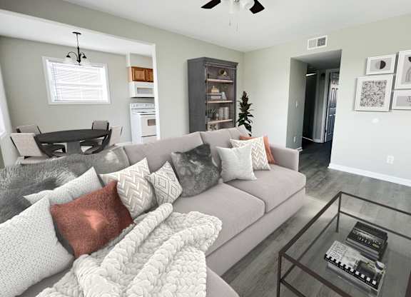 a living room with a gray couch and a glass coffee table