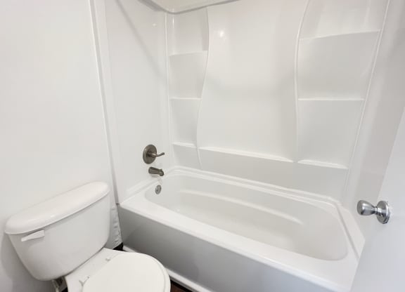 an empty bathroom with a toilet and a tub at Walnut Creek Townhomes, Ohio