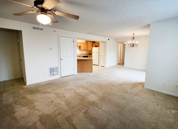 an empty living room with a ceiling fan and a kitchen  at Walton Ridge Apartments, Walton, Kentucky