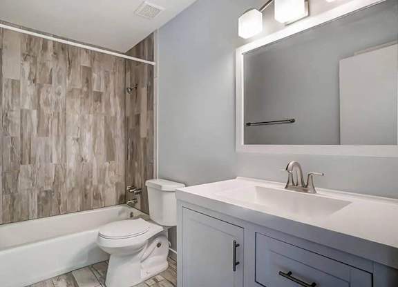 A white toilet sits next to a white sink in a bathroom.