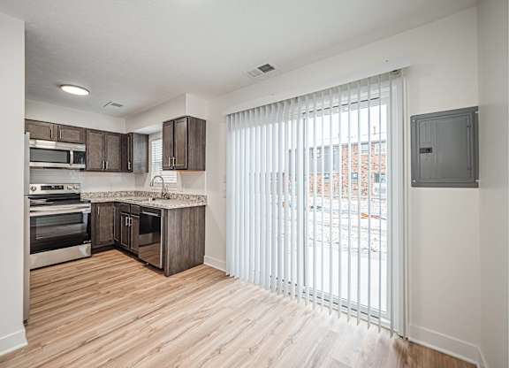 A kitchen with wooden floors and white walls.