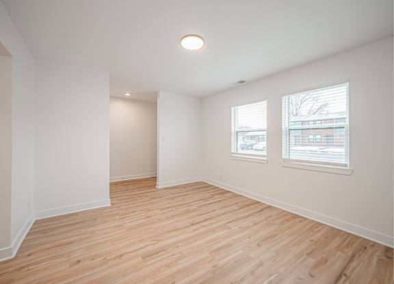 Empty room with wooden floor and white walls.