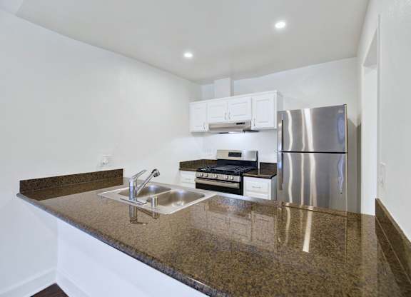 A kitchen with granite countertops and stainless steel appliances.