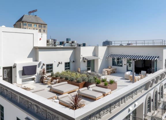 a roof terrace with furniture and a city in the background The Baxter in Los Angeles, CA 90028