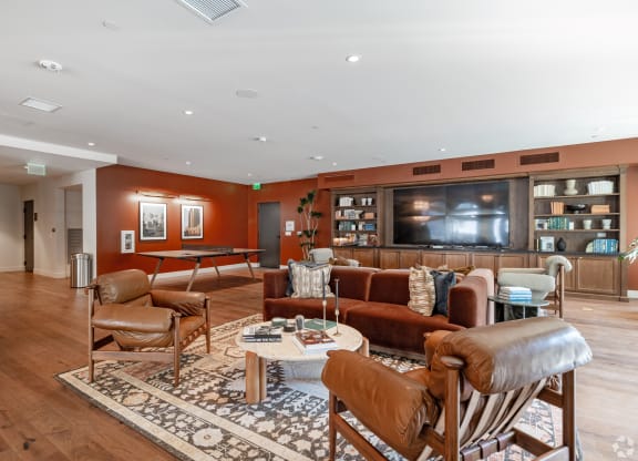a living room with couches and chairs and a television The Baxter in Los Angeles, CA 90028