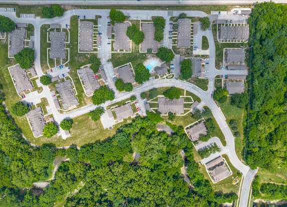 A bird's eye view of a residential area with houses, roads, and greenery.