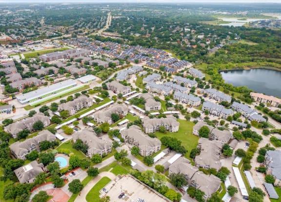 an aerial view of a neighborhood with houses and a lake at The Clairborne Apartment Homes, Grand Prairie, TX, 75050