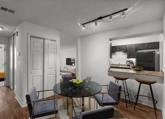 a dining room and kitchen with a glass table and chairs