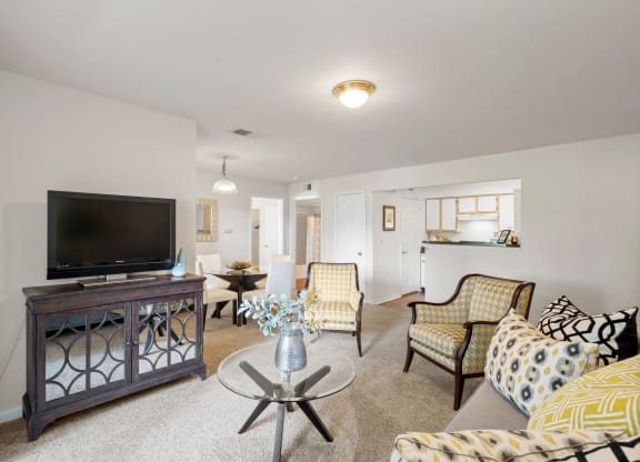 a living room with couches and chairs and a flat screen tv at Stonebriar Woods, Overland Park