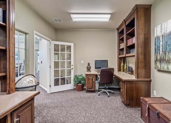 an office with a computer and a bookshelf